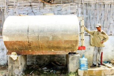 Endonezya 'da bir tuz tarlası işçisi 15 Kasım 2019' da Madura Endonezya 'da bir tankta taze su topluyor.