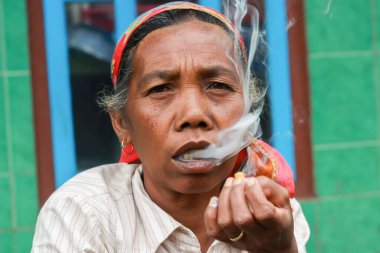 Sigara içen dişi bir çiftçinin yüz ifadesi. Tengger semeru, Malang Doğu Java Endonezya 21 Haziran 2024