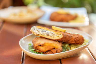 Alternatif dolgusu olan Cordon Bleu 'nun bir çeşidi açık hava bira bahçesindeki masada servis ediliyor.
