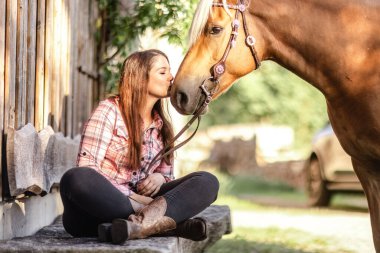 Kırsal kesimde Haflinger atıyla bağ kuran genç bir kadın.