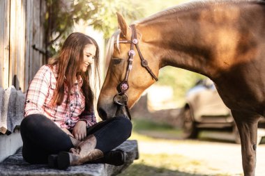 Kırsal kesimde Haflinger atıyla bağ kuran genç bir kadın.