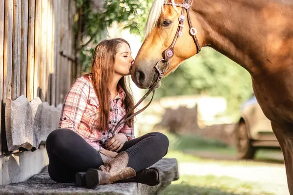 Kırsal kesimde Haflinger atıyla bağ kuran genç bir kadın.