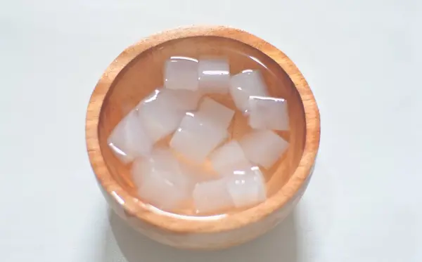 Beyaz arka planda kasede taze organik hindistan cevizi küpleri, hindistancevizi jeli ya da hindistan cevizli mata de coco
