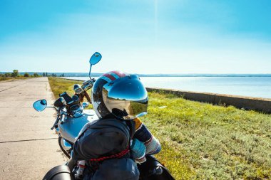 Nehrin kenarında duran motosikletli miğfer..