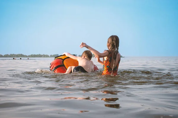 Παιδιά Παίζουν Στο Νερό Ένα Φουσκωτό Δαχτυλίδι — Φωτογραφία Αρχείου