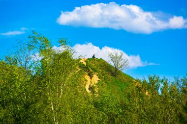 Bir tepenin üstünde oturan çift bulutların arkasında.