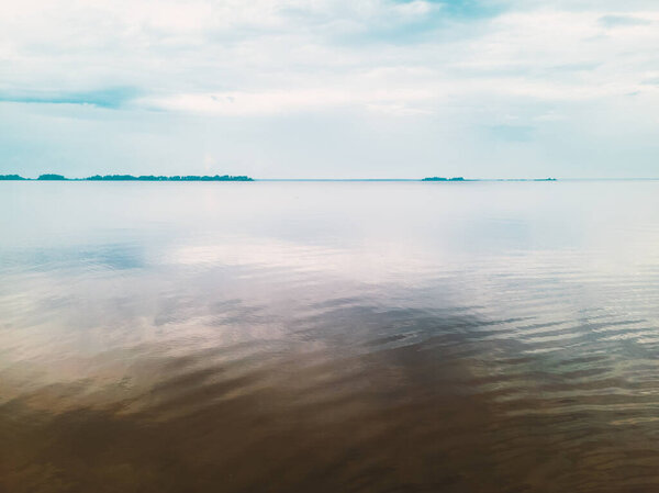 Serene water surface. Water meets clouds on the horizon