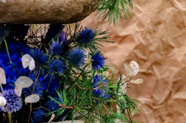 Buruşuk kağıt bir arka planda mavi çiçek ve çam dalları düzenleme.