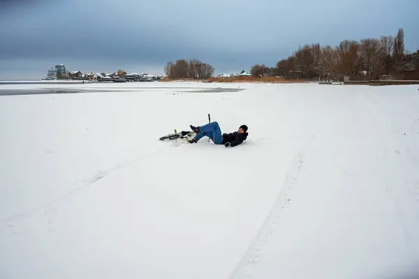 Chłopiec Spadł Roweru Podczas Jazdy Śnieżnym Brzegu Rzeki Zdjęcie Stockowe