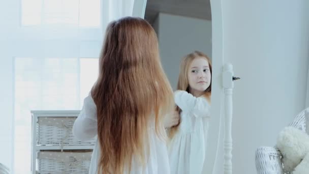 Ένα Κοριτσάκι Χαμογελάει Ενώ Χτενίζει Μαλλιά Της Και Κοιτά Τον — Αρχείο Βίντεο
