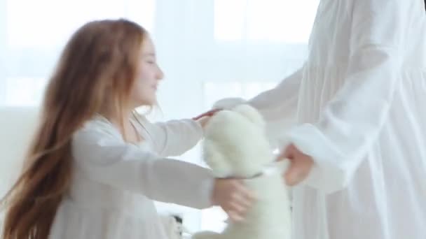 年轻的母亲和可爱的小女孩穿着老式的白色睡衣 在家里玩得很开心 在家里客厅里 带着女儿的女人手牵着手旋转跳跃 4K个视频 — 图库视频影像