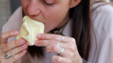 Genç bir kadın bir kafede geleneksel Gürcü khinkali 'sinin tadını çıkarıyor, iştahla bir ısırık alıyor, yakından..