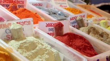Oriental Market 'te renkli kafkas baharatları çeşitleri, 4k video. İngilizce, Gürcüce ve Rusça harflerle yazılmış baharatların adı.