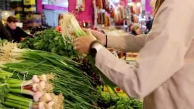 Genç bir kadın sebze seçiyor, marketten sebze alıyor, 4K video çekiyor.