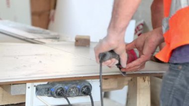 İşçi inşaat alanında alüminyum panel testereyle kesiyor, 4K yakın plan..