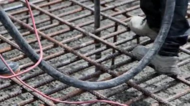 İnşaat işçileri inşaat sahasında temel dökerken bir kompresörle çalışıyorlar, yakın çekim 4K video.