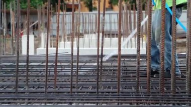 İşçi, inşaatın temelini atmadan önce hortumla tesisat ve form hazırlıyor..