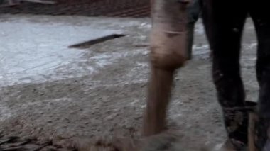 Erkek işçi inşaat alanında çalışıyor. Borudan beton döküyor. İnşaat alanı, temel döşeme, konsept, 4k, yakın çekim