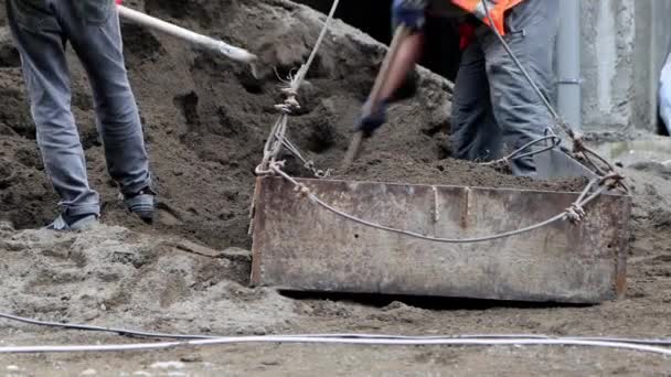 工人们用沙子填满了起重机的槽 工人们用铲子把沙堆在平台上 以便爬上大楼 — 图库视频影像