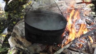 Kamp ateşinde kaynamış su kazanı, yakın plan.