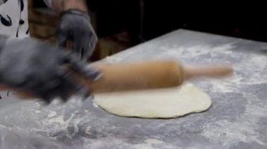 Hamuru pişirip peyniri şişte sarıyor. Khachapuri 'yi tükürükte, şişte pişirmek. Gürcistan ulusal mutfağı.