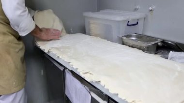 Aşçı, restoran mutfağında hamur çemberinden sıkıyor, 4K video.