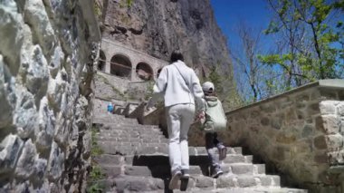 Türkiye 'deki tarihi Panagia Sumela Manastırı' na büyüleyici bir ziyaret. Bir anne ve kızı, ikonik turist beldesini keşfetmek için pitoresk merdivenlere tırmanıyor..