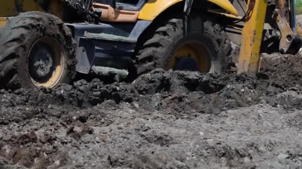 Uma Escavadora Move Através Canteiro Obras Suas Rodas Enterradas Lama — Vídeo de Stock
