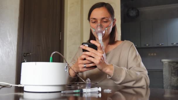 Ung Kvinna Andas Genom Mask Med Hjälp Nebulisator Med Smartphone — Stockvideo