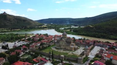 Mtskheta, Gürcistan 'ın havadan görünüşü, nehrin kıyısındaki ikonik Svetitskhoveli Katedrali ve Ortodoks kiliseleriyle antik şehrin ebedi güzelliğini gözler önüne seriyor..