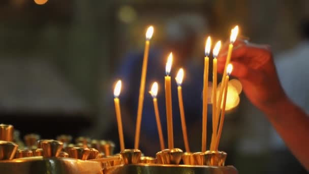 여자의 빛으로 교회에서 성스러운 분위기 부드럽게 촛불에 양초를 분위기를 만드는 — 비디오