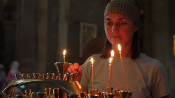 Portret Młodej Kobiety Świątyni Zapalającej Świecę Umieszczającej Świeczniku Kobieta Oświetlona — Wideo stockowe