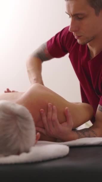 Male Masseur Actively Rubbing Patient Back Focuses Shoulder Blade Young — Stock Video
