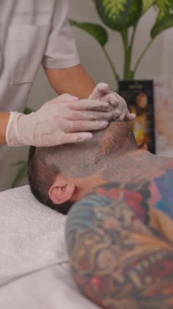 Uppfriskande Hudvårdsrutin När Ung Man Hänger Sig Medicinerad Ansiktsmask Skönhetssalongen — Stockvideo