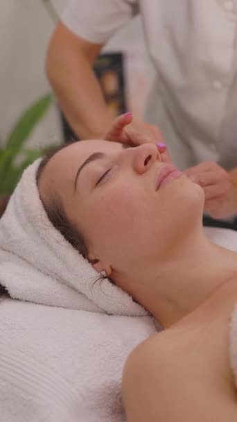 Terapeutisk Ansiktsmassagebehandling För Ung Vacker Kvinna Massageterapeuten Gör Speciella Avslappnande — Stockvideo