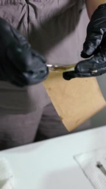 Manikür aletleriyle sterilizasyon hazırlığı düzgün bir şekilde tek kullanımlık kraft torbalara doldurulmuş. Manikür sürecinde hijyen ve güvenliği sağlamak. Dikey görüntüler.