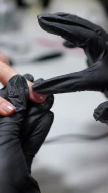 Profesyonel manikür: parlak bir son için tırnaklara sim sürtünmesini içeren yakın çekim dikey görüntü.