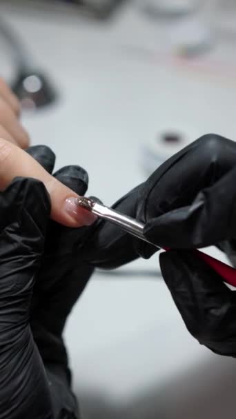 在修指甲过程中 用刷子在女性指甲上涂上凝胶抛光剂的详细特写 垂直视频格式 — 图库视频影像