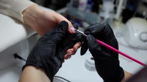 在指甲修整过程中 用刷子在指甲上涂胶水的特写 女性手部的专业修指甲 — 图库视频影像