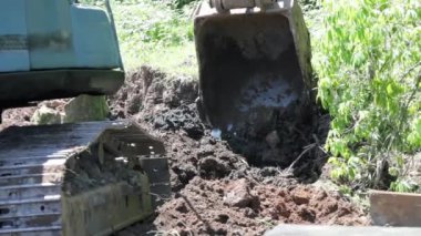 İnşaat sahasında kazı yapan bir kazıcının yavaş çekim görüntüleri. Bölgeyi inşaat çalışmalarına hazırlıyor..