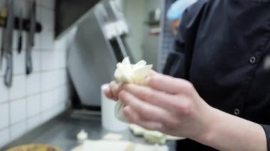 Restoran mutfağında bir aşçı, geleneksel bir Gürcü yemeği olan Khinkali 'yi şekillendirmek için hamuru çabucak doldurur. Gürcistan mutfağı veya mutfak teknikleri sahneleri için mükemmel..