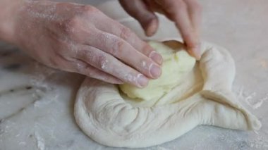 Adjarian khachapuri pişirmek, şef elleri, yakın plan, hamur ile peynir yaymak. Gürcü yemekleri.