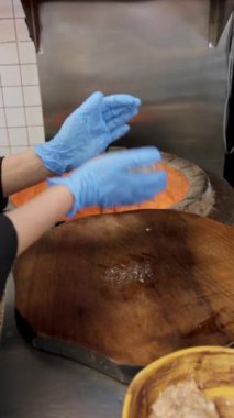 Restoran mutfağı, tandoor 'da ateş yanıyor, tuğla fırın, eldiven ve kıyma şeklinde şefin ellerini yakın çekim. Dikey Video, Yavaş Hareket.