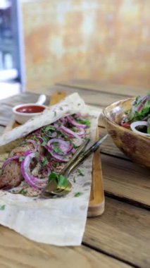 Bir kase sebze salatası ve Pita ekmeğine soğanlı lula kebabı. Dikey video formasında Kafkas mutfağının iştah açıcı yemekleri