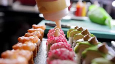 Restoran mutfağı, yakın plan suşi, üstüne mayonez sosu. Suşi pişiriyorum. Suşi hazırlıyorum..