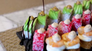 Japon yemeklerini gösteren balzamik sirke serpiştirilmiş bir suşi setinin yakından görüntüsü..