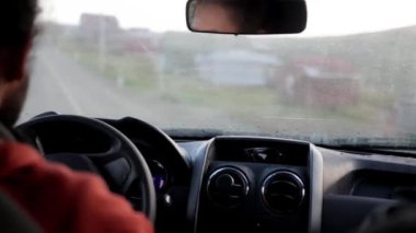 Kötü hava koşullarında, kır yolunda giden bir arabanın içinden bir manzara. Video yağmurla ıslanmış manzarayı ve kırsal yollarda zorlu koşullarda gezinmenin zorluklarını kaydediyor..