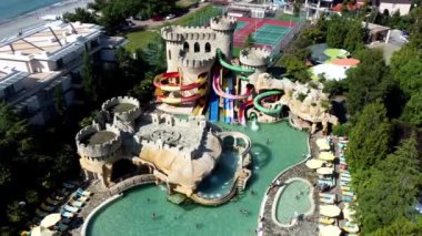 Georgia 'da deniz kıyısında bulunan Oasis Su Parkı' nın hava manzarasını keşfedin. Güzel manzarayla çevrili renkli slaytların ve havuzların tadını çıkarın. Seyahat ve eğlence için mükemmel.!