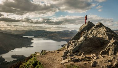 Ben A 'an Zirvesi' nden Katrine Gölü 'nün manzarası. Dağın tepesinde bir kadın duruyor. Lommond Gölü ve Trossachs Ulusal Parkı. İskoçya. Yürüyüş. Macera. Tepe Yürüyüşü