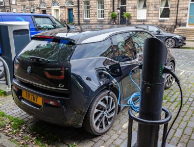 Edinburgh, İskoçya, 07.17.2024: Siyah Mercedes elektrikli araba Edinburgh 'da kaldırımlı bir caddede şarj noktasında pillerini şarj ediyor